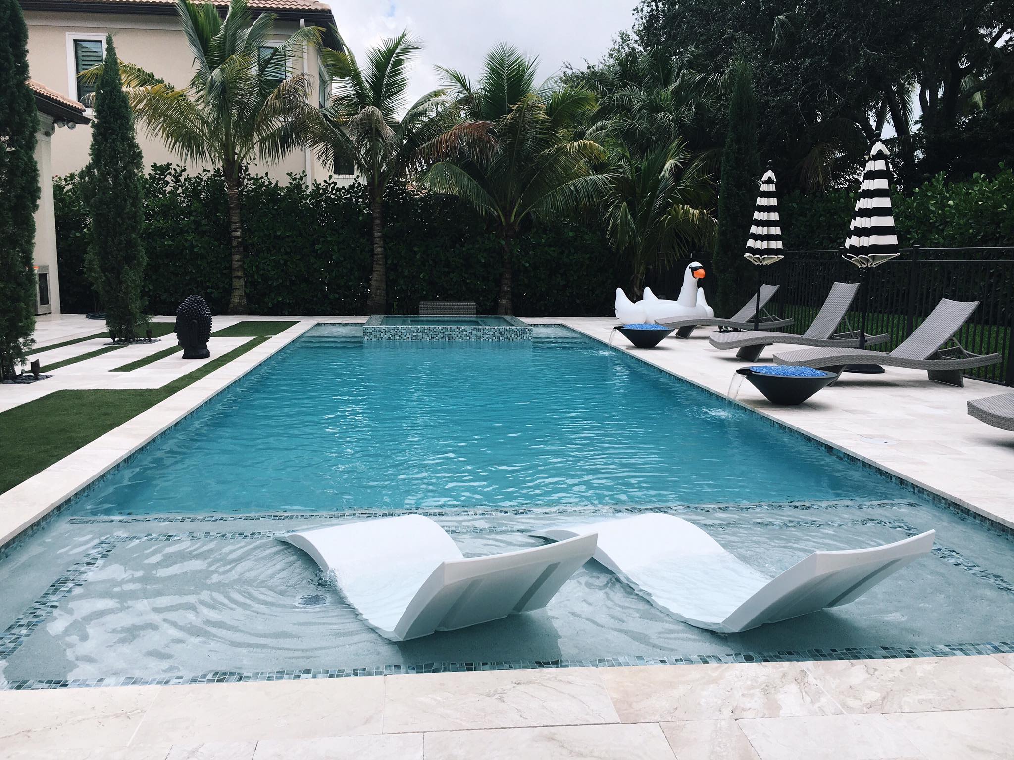 A pool view with some ledge lounger chairs